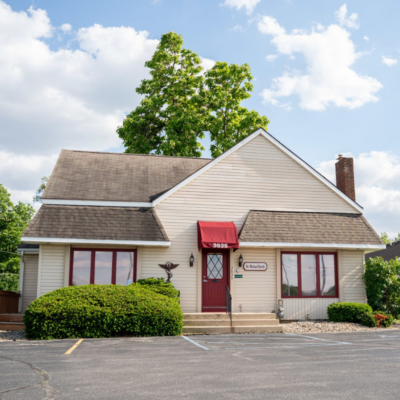 Front exterior of the Fort Wayne Southwest clinic featuring yellow siding, a maroon awning, and the main entrance.